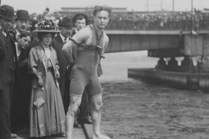Harry Houdini jumps 30 feet from Harvard Bridge locked up in chains, April 30, 1908. Boston, Massachusetts. His hands were handcuffed and chained to a collar around his neck by a Boston policeman in f