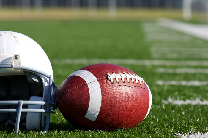 American Football and Helmet on the Field with room for copy