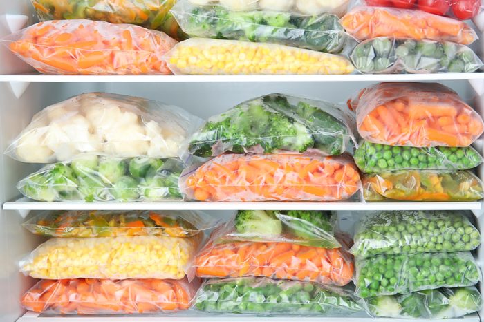 Plastic bags with deep frozen vegetables in refrigerator