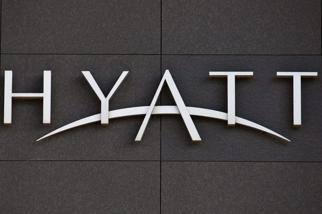 White "HYATT" sign mounted on a dark tiled wall.