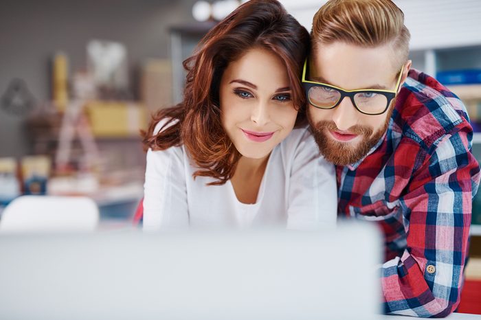 Closeup of happy couple looking at laptop