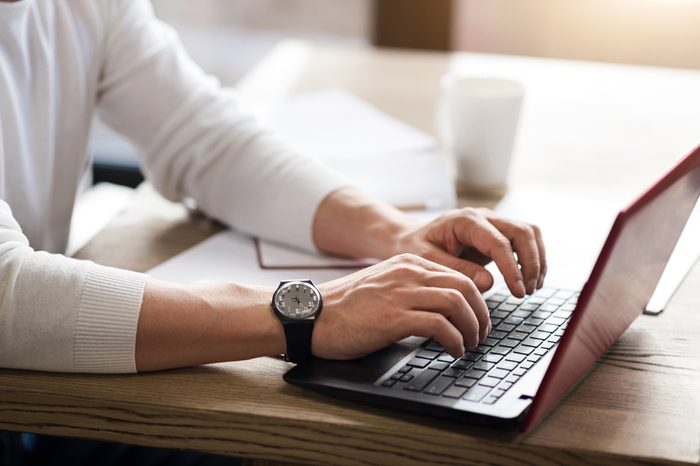 Close up of man typing on computer