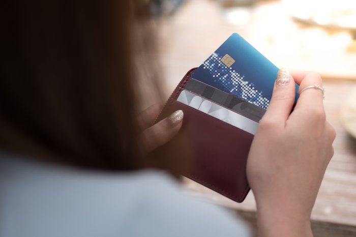 women is selecting credit card from her card wallet