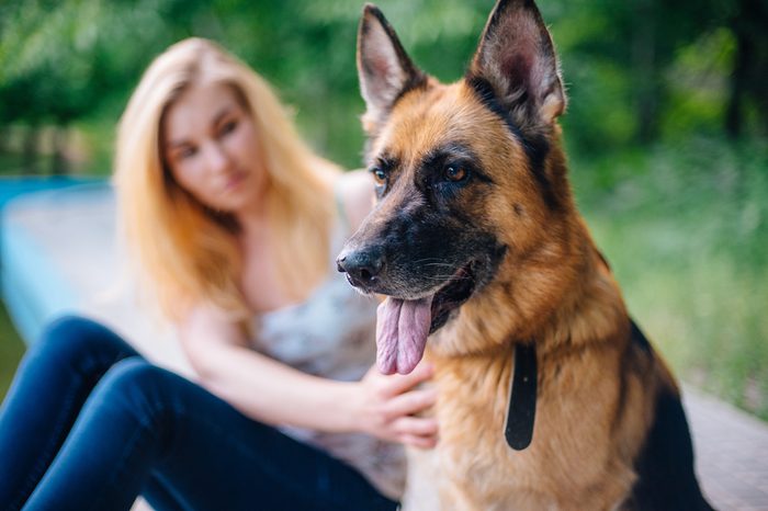 female with german shepherd dog in park