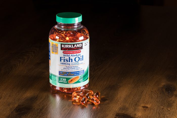 Kirkland Wild Alaskan Fish Oil capsules and bottle on wooden table