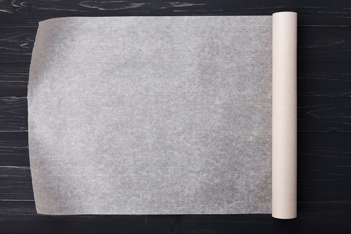 Baking paper on wooden kitchen table for menu or recipes, top view