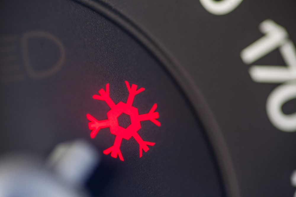 Red snowflake icon illuminates against a dark, circular background, indicating cooling or air conditioning within a vehicle dashboard setting.