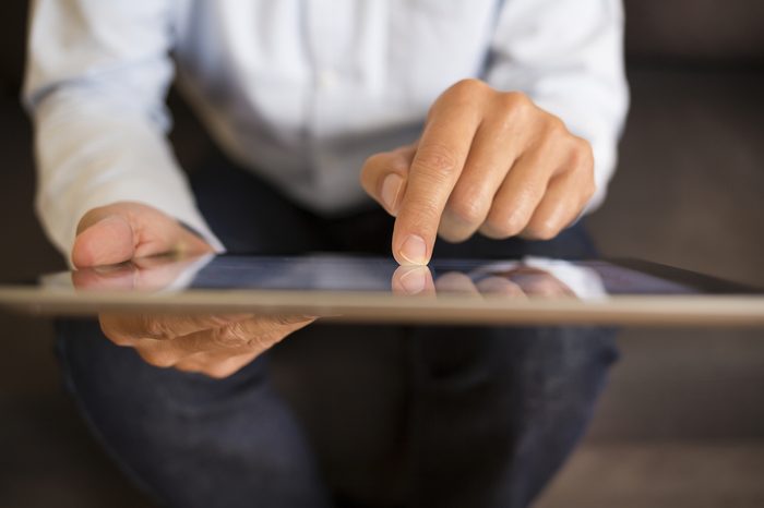 Man using a Tablet Pc on sofa, indoor 