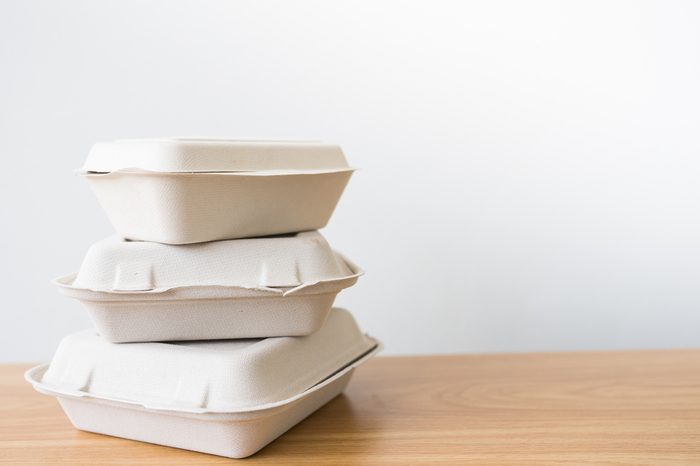 Stack of natural plant fiber food box on wooden background.