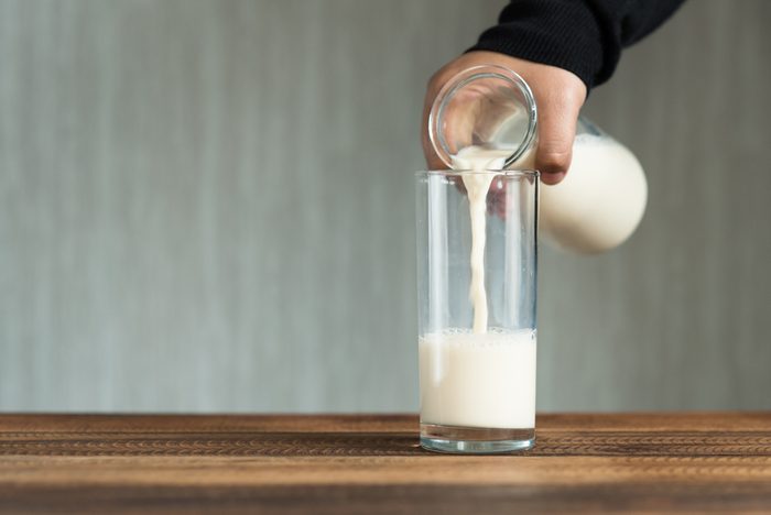 pouring milk into glass. filling a glass with milk.