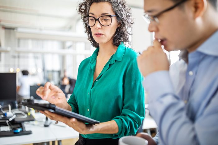 Businesswoman explaining business plan on digital tablet to colleague. Business people having a meeting in office.