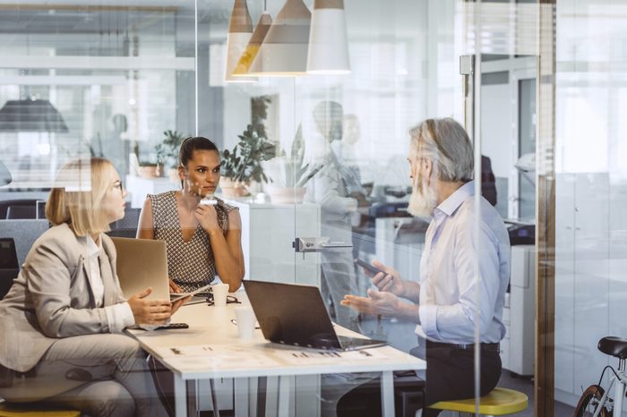 Business People Sitting at Desk, Discussing