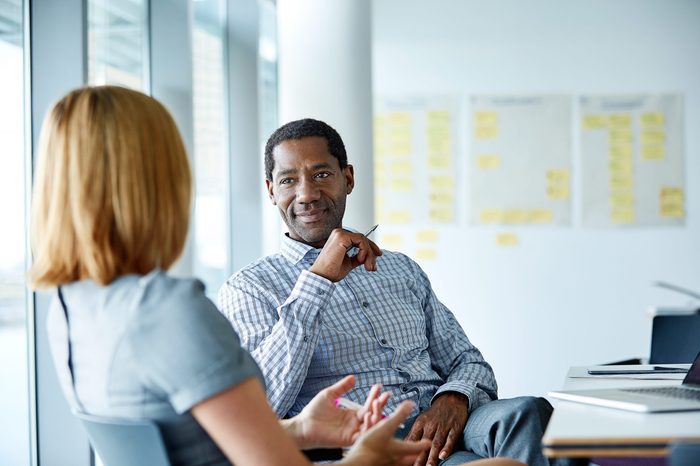 Shot of two colleagues talking together while sitting in a modern office