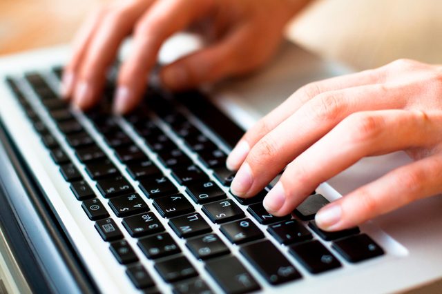 A white computer keyboard rests on a dark surface, showing the top right section with function keys and arrow keys prominently displayed.