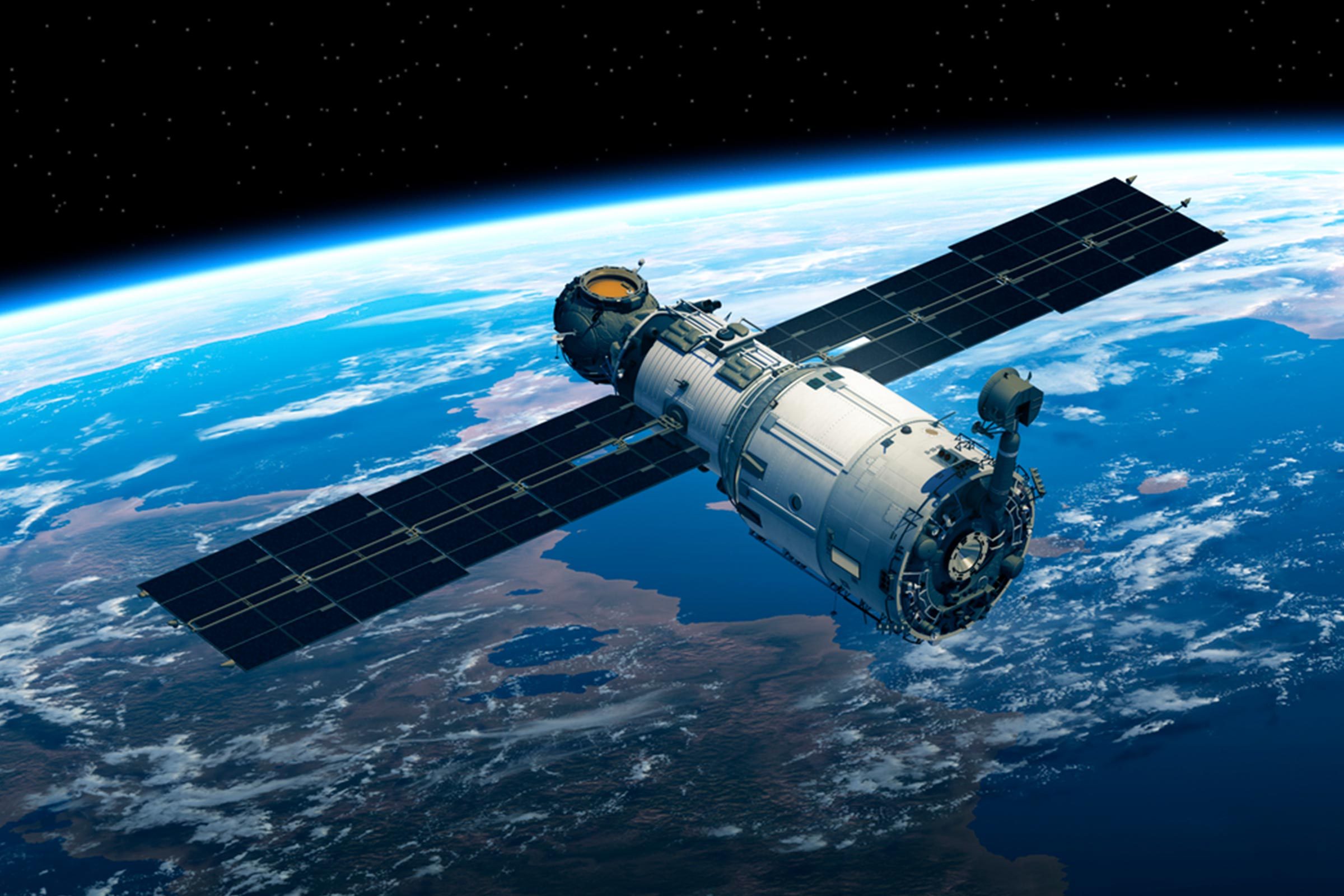 A satellite orbits above Earth, displaying solar panels against the vast backdrop of space and the planet's blue expanse.