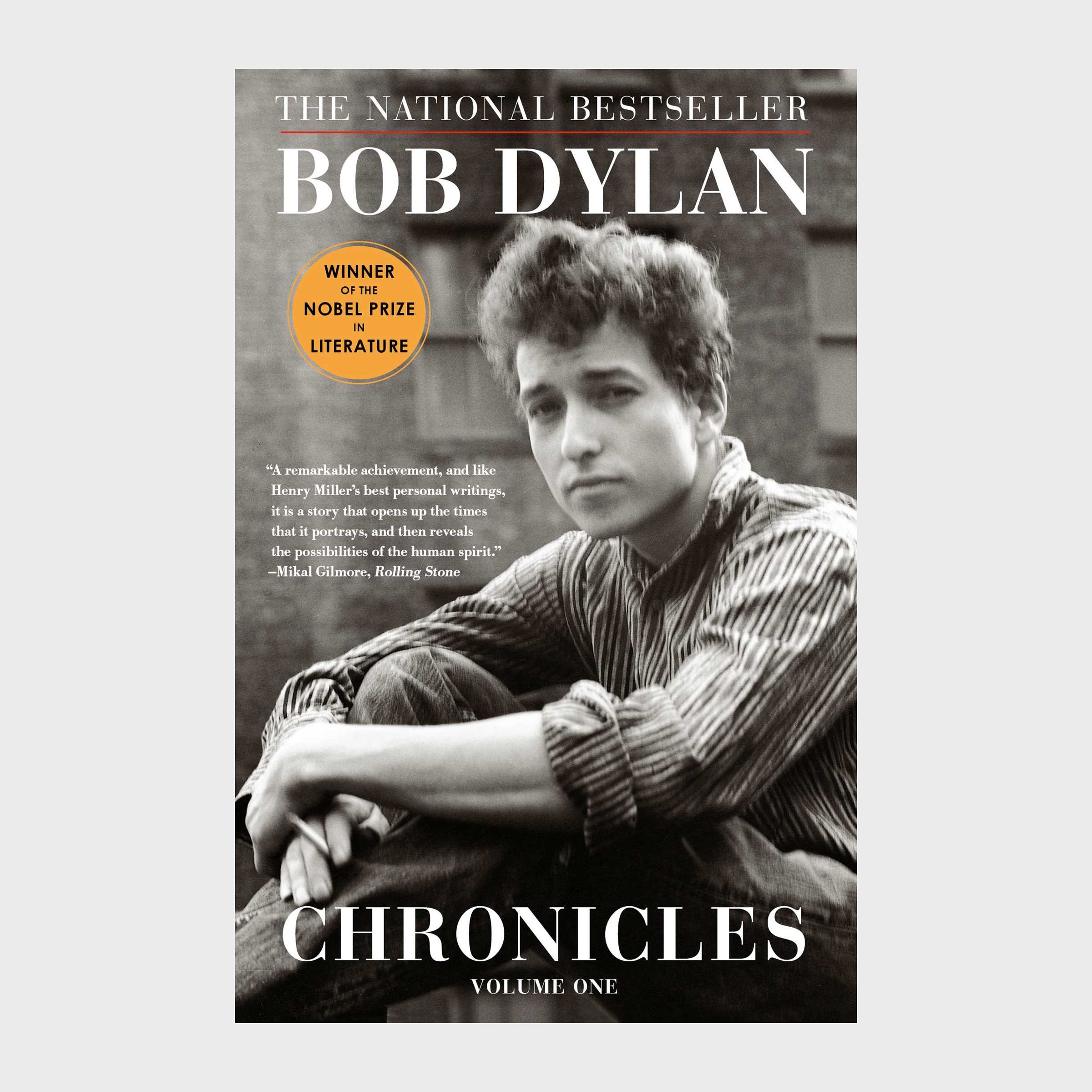Book cover shows a thoughtful person sitting, arms crossed; titled "Bob Dylan Chronicles Volume One," with a Nobel Prize sticker beside.