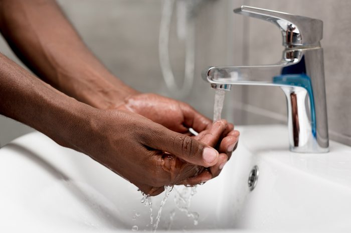 close-up partial view of african american man washing in bathroom