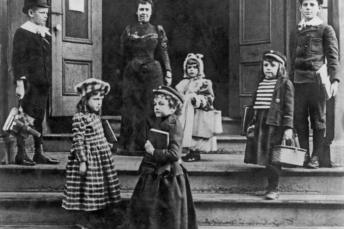 Children arriving at school with their books straps