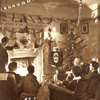 A family sits watching an early television in a warmly decorated living room, featuring a Christmas tree and garlands, creating a festive atmosphere.