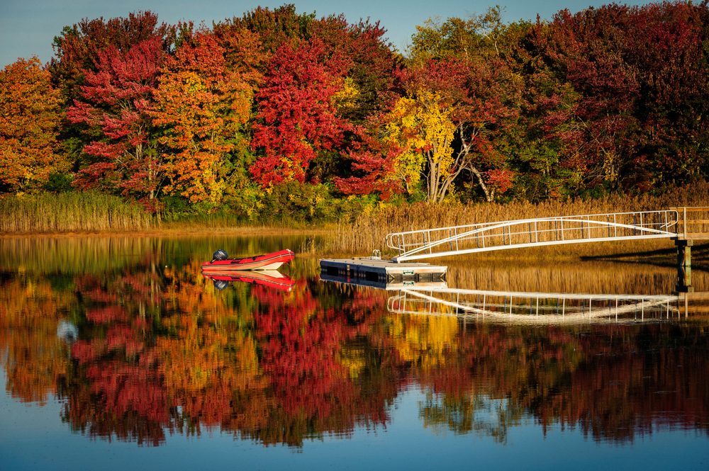 Dinghy on lake with fall foliage near Kennebunkport, Maine in autumn