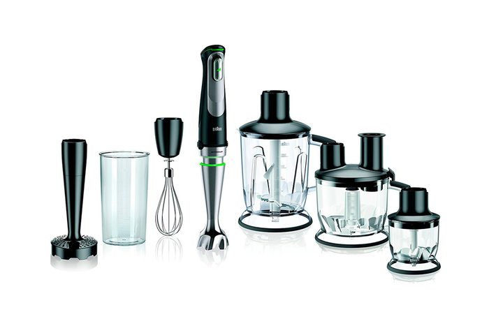 Kitchen blender set arranged neatly, featuring various attachments like a whisk, chopper, and beaker, all against a white background.