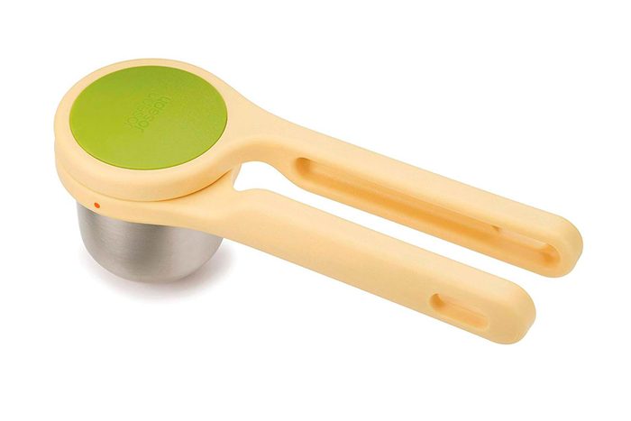Handheld citrus juicer, plastic and metal, lies open on a white background.
