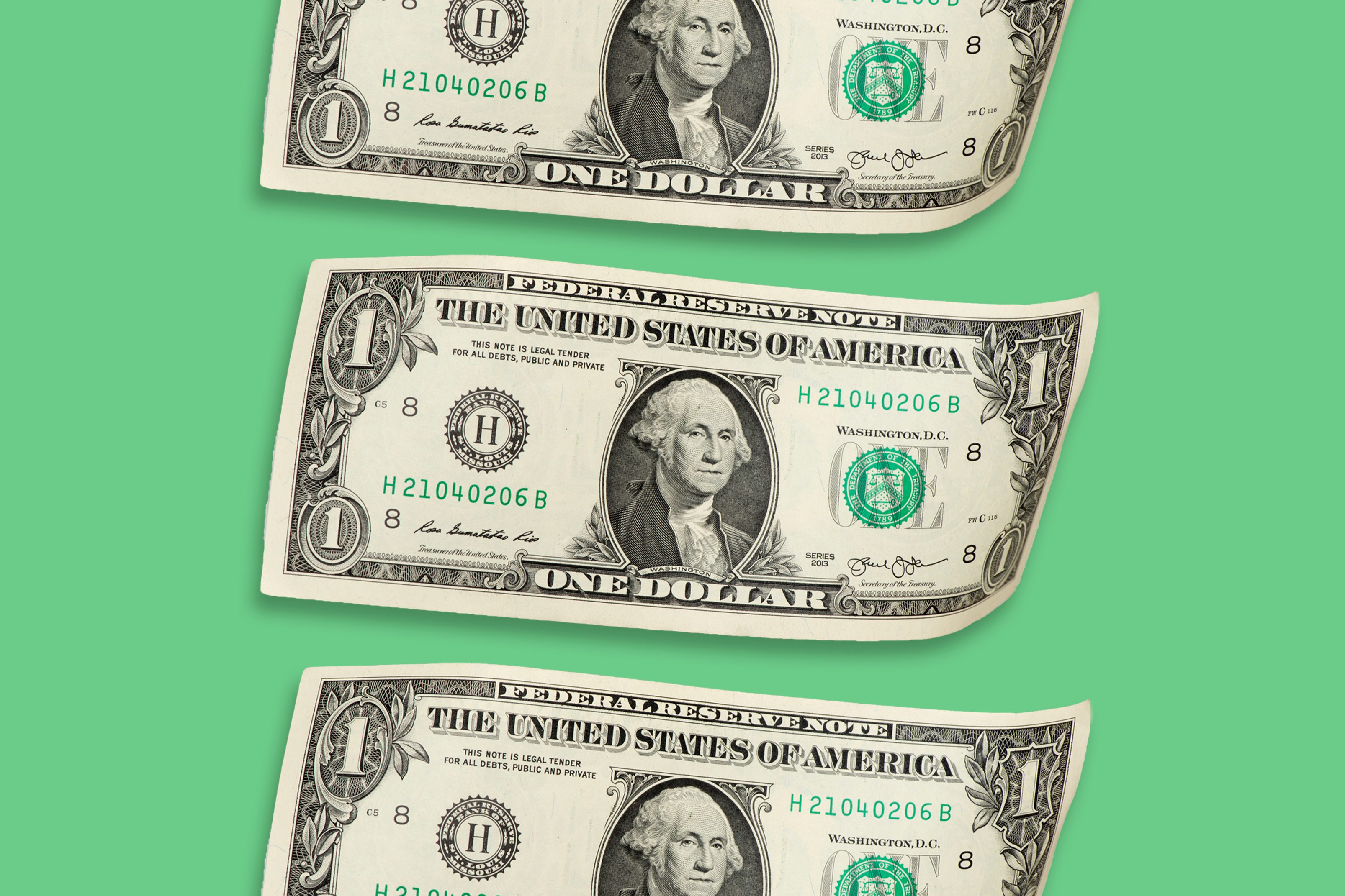 Three U.S. one-dollar bills aligned horizontally on a green background.
