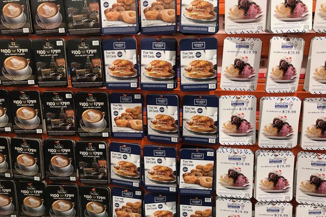 Gift card display showing premium coffee, donuts, sandwiches, and ice cream options for purchase in a retail environment.
