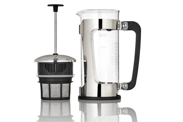 French press disassembled, revealing metal and nylon filter beside clear glass carafe, against a white background, with a black handle.