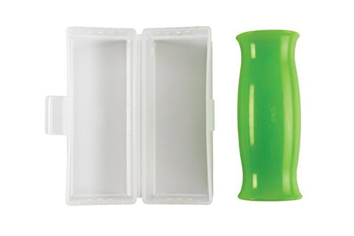 Green silicone tube rests beside an open white rectangular case on a plain background. Text 