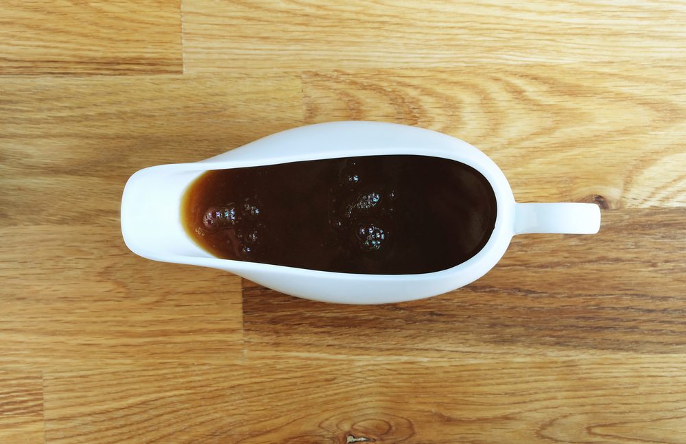 Gravy boat full of gravy shot from above on wooden table
