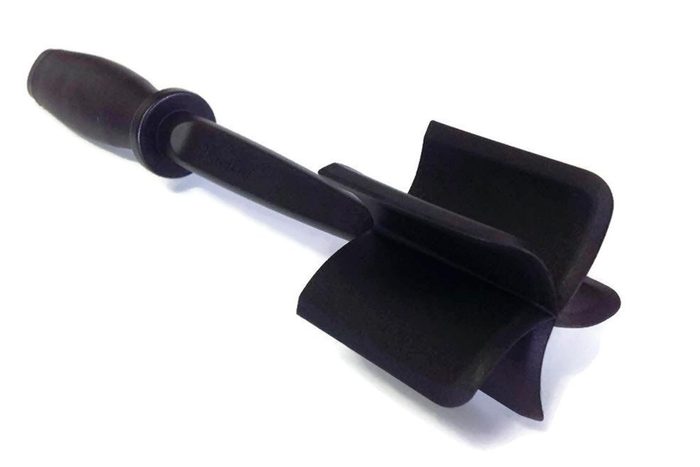 Dark plastic kitchen utensil with a handle attached to three blades, resting on a white surface.