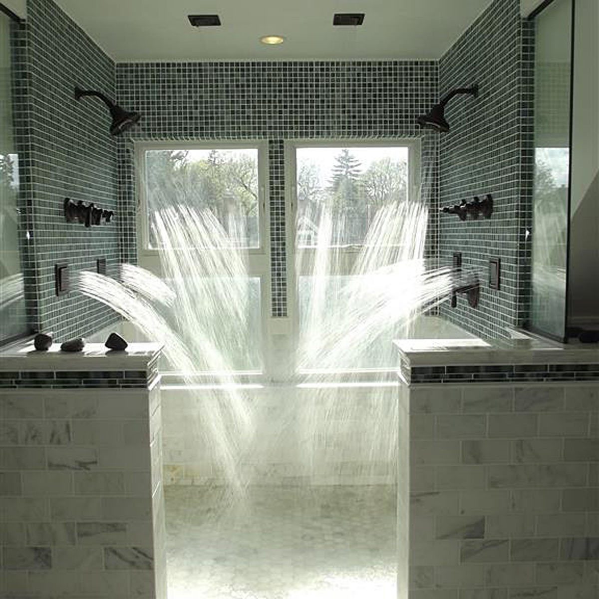 Water sprays diagonally from multiple showerheads, creating streams across a tiled bathroom. Sunlight filters through windows in the background.