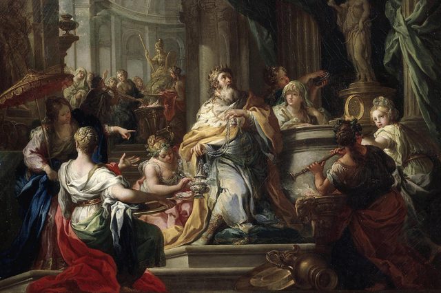 A bearded king holding incense is surrounded by elegantly dressed attendants in a grand, ornate hall with statues and draped fabrics.