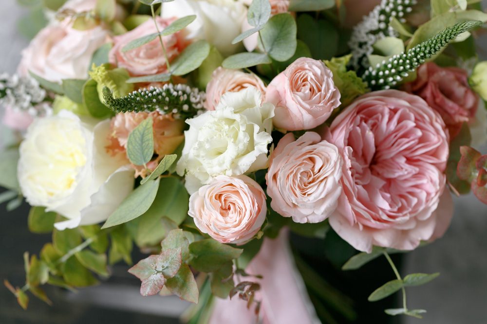 Spring bouquet of mixed flowers on vintage gray wall background behind