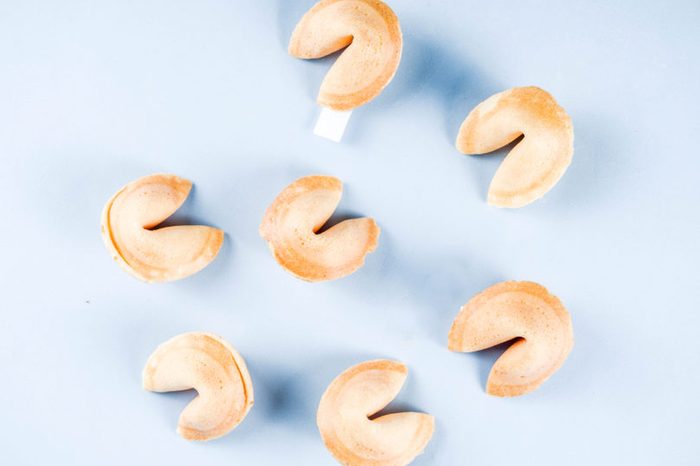 Chinese fortune cookie with prediction on light blue background top view copy space