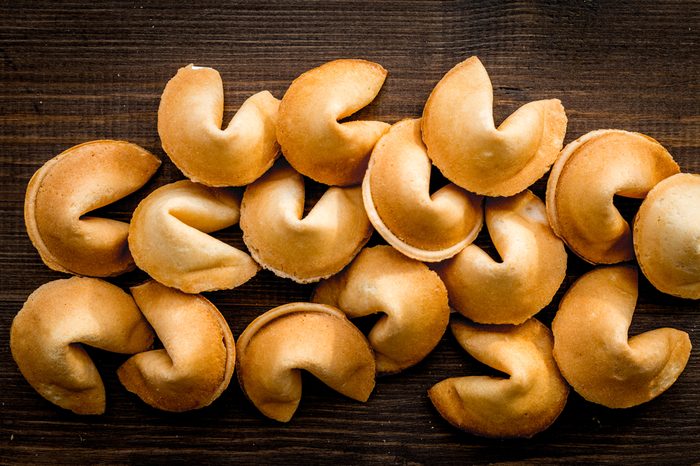 Prediction in fortune cookie on white background flat lay