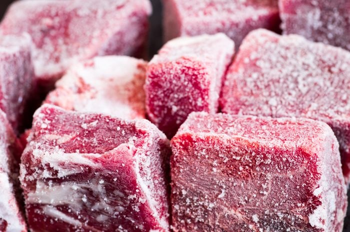 Frozen beef pieces with hoarfrost texture closeup