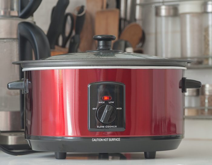 Close up of a slow cooker working on kitchen shelf