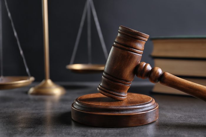 Judge's gavel and blurred scales on background. Law concept