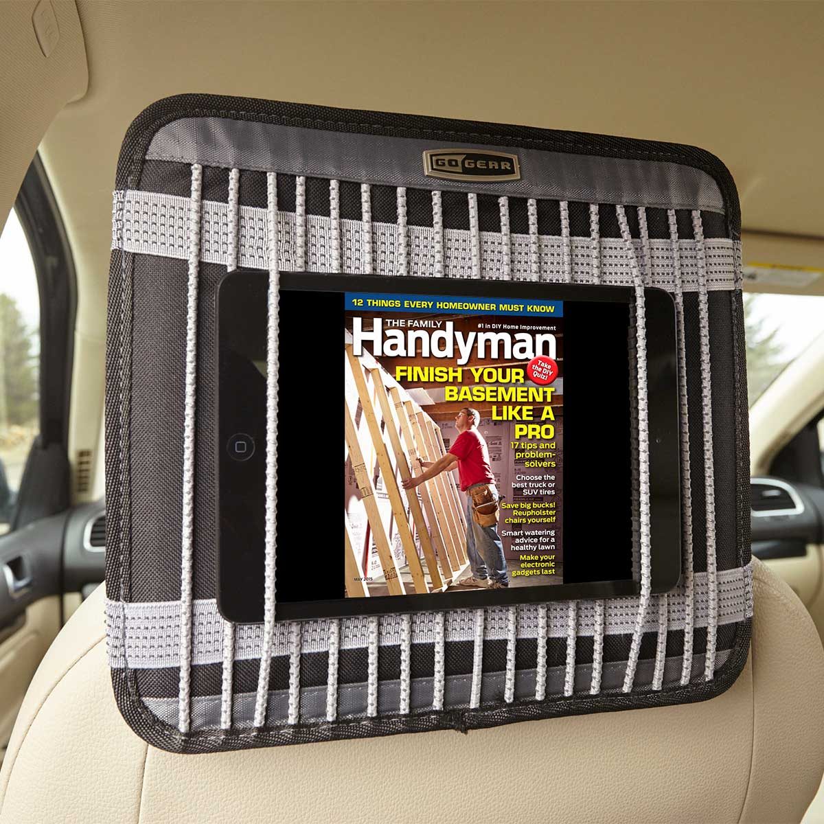 Tablet displaying magazine, secured in headrest organizer, inside a car.