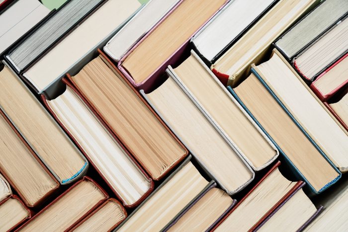 Many Books Piles. Hardback books on wooden table. Back to school. Copy space