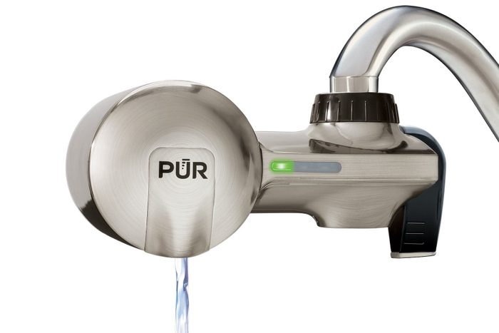 Water filter dispensing clear water, attached to a metal faucet; logo 
