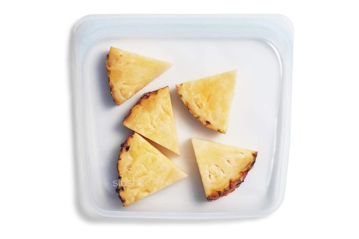 Pineapple slices arranged in a clear storage bag on a white background. 