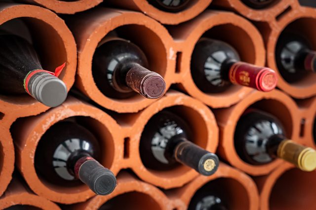Wine bottles stored horizontally in terracotta tubes, forming a compact grid structure.
