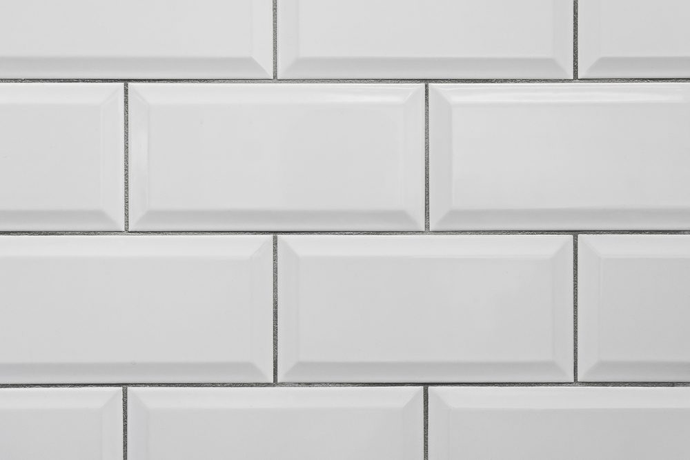 White rectangular tiles arranged in a staggered pattern, forming a clean, geometric wall design.