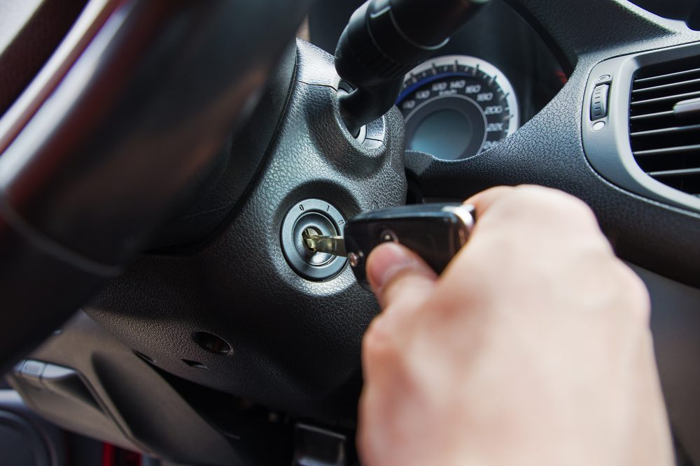 Close-up Of Person's Hand Inserting Key To Start Car