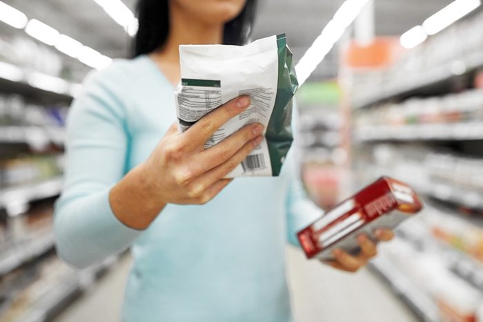 sale, shopping, consumerism and people concept - close up of woman with food at grocery store