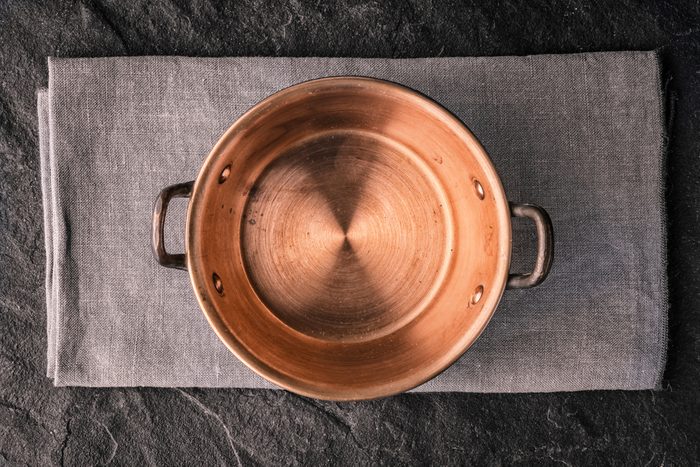 Copper pot on the dark stone table top view