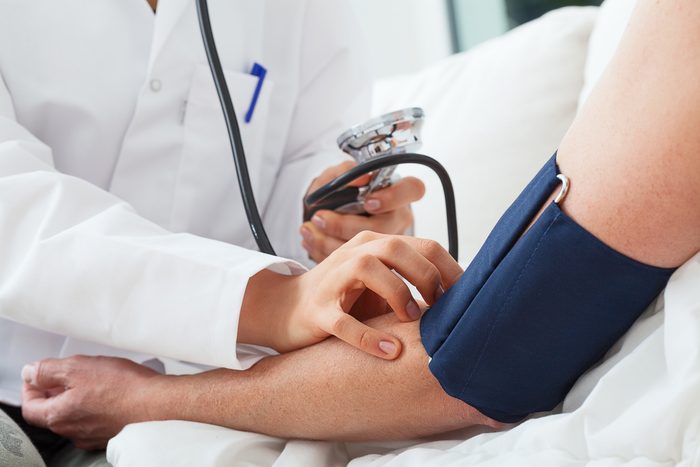 Doctor is taking patient blood pressure with a pressure gauge